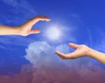 Hands Reaching Out In Sky Stock Photo