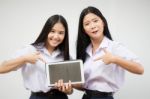 Two Asia Thai High School Student Uniform Best Friends Beautiful Girl Using Her Tablet And Funny Stock Photo