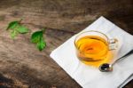 Glass Cup Of Tea And Spoons With Green Leaves Tea On Old Wooden Stock Photo