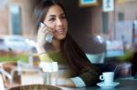 Beautiful Girl Using Her Mobile Phone In Cafe Stock Photo