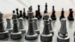 Light And Dark Wooden Chess Pieces On Chess Table Stock Photo