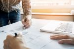 Architects Engineer Discussing At The Table With Blueprint - Clo Stock Photo