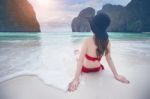 Young Woman In Red Bikini Sitting On The Beach Stock Photo