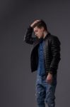 Casual Young Man In Black Leather Jacket And Denim Jeans Stock Photo