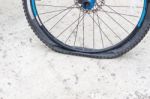 Bicycle Wheel With Flat Tyre On The Concrete Road Stock Photo