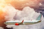 Airplane Flying Above Clouds In Sunlight Stock Photo