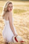 Lonely Beautiful Young Blonde Girl In White Dress With Straw Hat Stock Photo