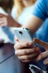 Group Of Friends Using Mobile Phone In Cafe Stock Photo