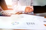 Two Business People Shaking Hands While Sitting At The Working P Stock Photo