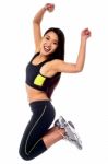 Woman In Sportswear Jumping With Joy Stock Photo