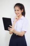 Portrait Of Thai High School Student Uniform Beautiful Girl Using Her Tablet Stock Photo