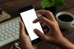 Closeup Hand Use Phone Showing White Screen On Work Desk, Blank Stock Photo