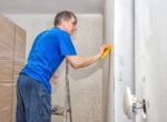 Man Smoothes The Wallpaper With A Spatula Stock Photo