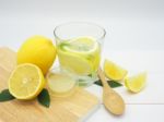 Fresh Lemon In Water, Lemonade And Lemon Slice On White Wood Bac Stock Photo