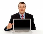 Businessman Pointing At Blank Laptop Screen Stock Photo