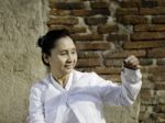 Woman Playing A Bell, Traditionally Used To Aid Meditation In Bu Stock Photo