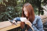 Happy Young Woman Drinking Coffee Outdoors And Using Smartphone Stock Photo