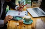 Business Man Sitting On A Calculator To Figure Out In A Coffee S Stock Photo