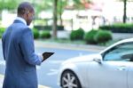 Back View Of African Man Holding Tablet Stock Photo