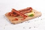 Wooden Chopping Board With Sausages And Spices Stock Photo