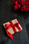 Gift  With A Red  Bow And Bouquet Of Roses Stock Photo