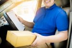 Delivery Man With Cardboard Box Checking Document List In Van An Stock Photo