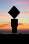 Road Sign Silhouette And Colorful Sunset Stock Photo