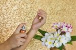 Women Hand Spraying Perfume At Wrist With Flowers In Vase And Cl Stock Photo