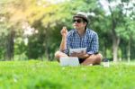 Portrait Of A Concentrated Casual Man In Hat Holding Notebook An Stock Photo