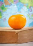 Orange On An Old Book Stock Photo