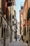 People Walking Along A Narrow Street In Venice Stock Photo