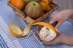 Woman Hands Peeling An Orange With A Knife Stock Photo