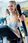 Young People With Elliptic Machine In The Gym Stock Photo