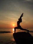 Silhouette Yoga Girl By The Beach At Sunrise Stock Photo