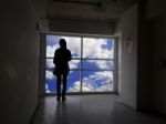 Women Silhouette Beside The Big Window And Sky Background Stock Photo