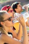 Group Of Friends Drinking Water In The Park Stock Photo