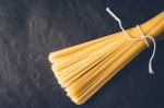 Raw Spaghetti On The Black Stone Background Stock Photo