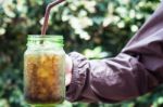 Woman Hand Holding Iced Soda In Green Glass Stock Photo