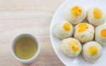 Chinese Pastry Mung Bean Or Mooncake With Egg Yolk On Dish Wooden Table And Green Tea Cup Stock Photo