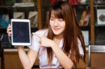 Portrait Of Thai Adult Student University Uniform Beautiful Girl Using Her Tablet Stock Photo