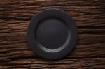 Black Empty Plate On Wooden Table Background Stock Photo