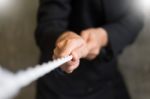 Hand Pulling The Rope, Grey Background, Cooperation Concept As A Stock Photo