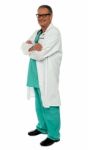 Smiling Senior Doctor Arms Crossed Stock Photo