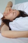 Asian Lying On White Bed Stock Photo