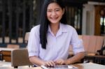 Portrait Of Thai High School Student Uniform Beautiful Girl Using Her Tablet Stock Photo