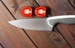 Fresh Cut Tomatoes With Knife On The Dark Wooden Table Stock Photo