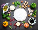 The Ingredients For Homemade Pizza On Dark Stone Background Stock Photo