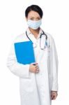 Surgeon Holding Clipboard. Face Covered With Surgical Mask Stock Photo