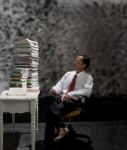 Man Looking To Big Stack Of Book On Working Table Stock Photo