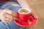 Woman In Torn Jeans Sitting At Coffee Shop Stock Photo